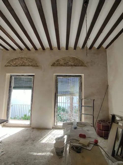 Interior en obra con vigas de madera y arcos históricos en Chiclana
